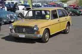 A vintage golden sedan parked at a classic car show, basking in the sunshine, catches the eye of enthusiasts looking to secure a $1500 loan for their own classic finds.