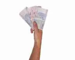 A hand holding a fan of banknotes against a white background, symbolizing the need for a 5000 loan.