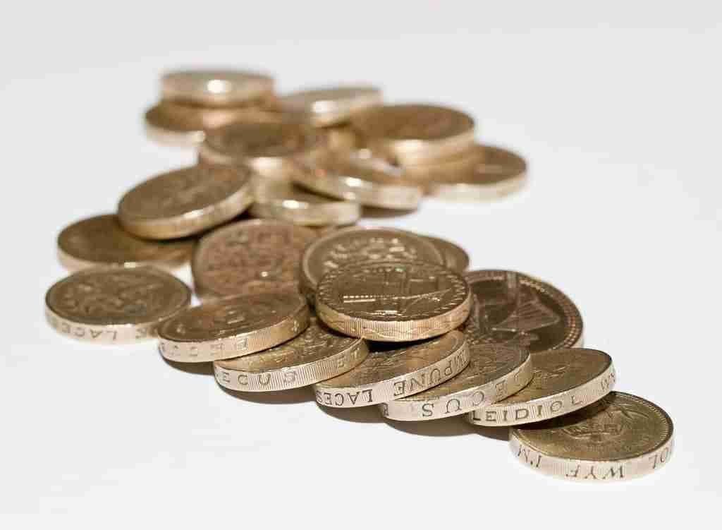 A pile of various coins scattered on a white surface. uk unsecured personal loans