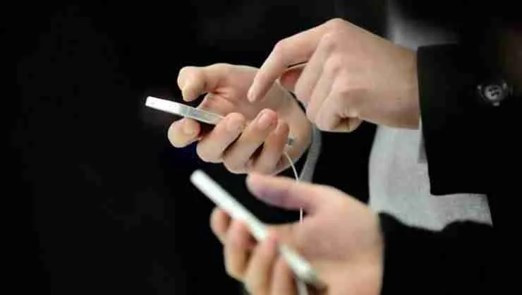 Two people engaged in modern communication, typing on their cell phones for people with bad credit with focus and dexterity.