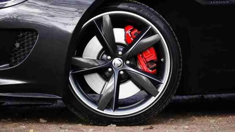 Sleek sports car with distinctive black alloy wheel, red brake caliper, and quick personal loans available.