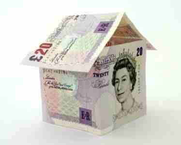 House model made from British pound sterling banknotes, symbolizing real estate investment or the cost of housing for tenants through loans.