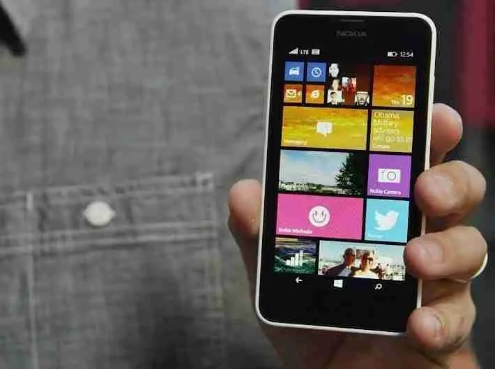 A person holding a smartphone with a colorful tiled interface display, showcasing bad credit contract phones.