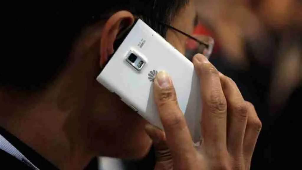A person holding a white smartphone to their ear, engaged in a conversation over their contract phone with no credit check.