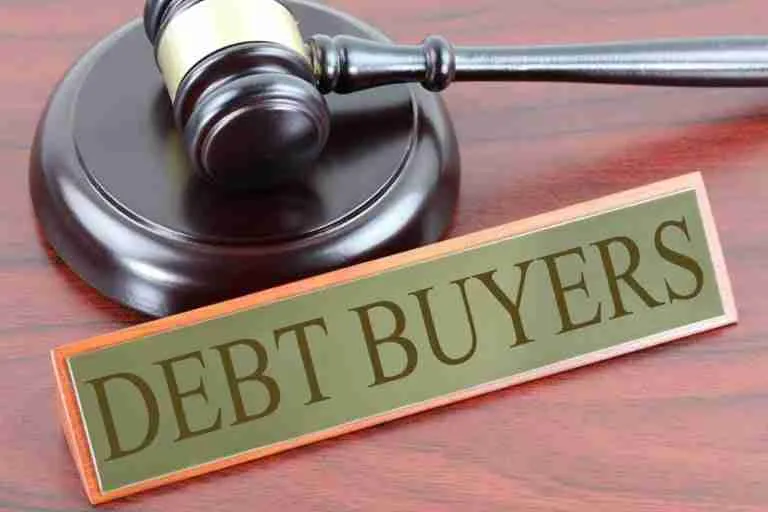 Gavel on a desk signifying the legal aspect of debt trading, next to a sign that reads "debt buyers," indicating a focus on the business of purchasing defaulted or distressed debt.