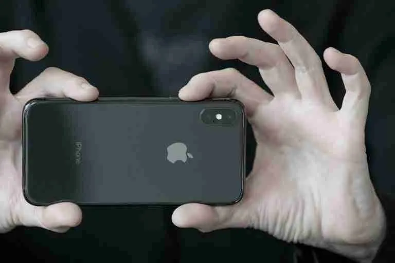 Hands conjuring an air of mystery while holding a smartphone, with a focus on modern communication's invisible magic.