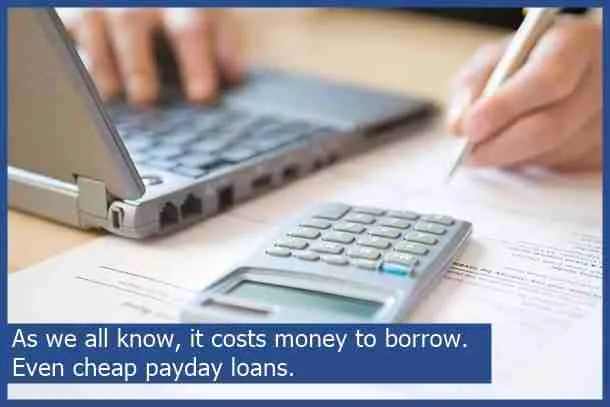 A person calculating finances on a document with a calculator and laptop, emphasizing the costs associated with payday loans and bad credit no guarantor loans.